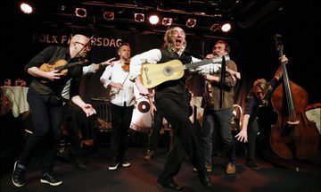 Musicians performing on stage and dancing energetically