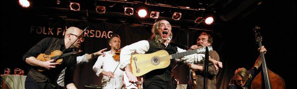 Musicians performing on stage and dancing energetically