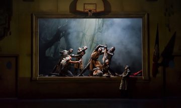 Two men dressed in armour holding sword over another, others reaching inwards towards them in framed scene