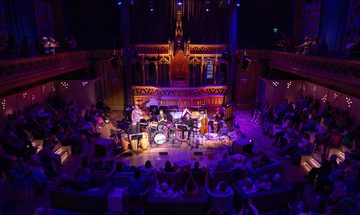 Musicians performing to an audience in large theatre