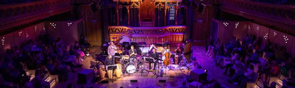 Musicians performing to an audience in large theatre