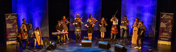 Group of musicians playing instruments on stage to audience