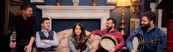 group of people sitting with instruments, woman in centre facing forward