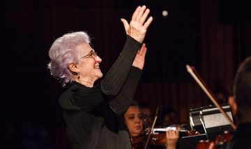 Woman holding arms in air conducting orchestra