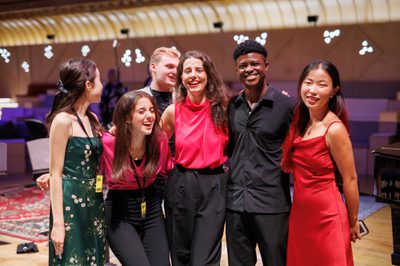 Group of young adults standing arm in arm smiling and laughing