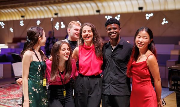 Group of young adults standing arm in arm smiling and laughing