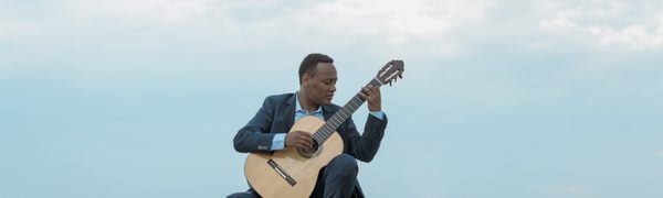 Man sitting outdoors Playing guitar
