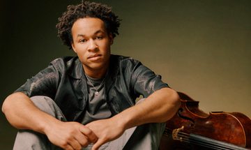Man sitting in front of stringed instrument