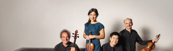 Four string-players smile at the camera