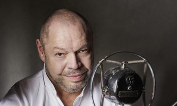 Man behind microphone facing the camera