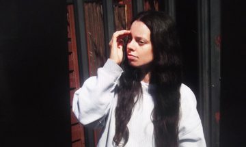 Woman with long dark hair looking off camera