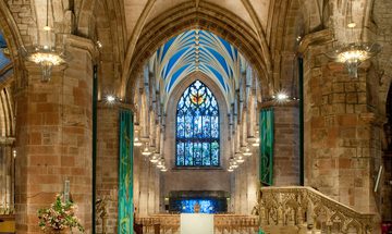 a high ceiling church with stained glassed windows