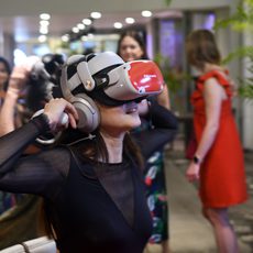 Woman wearing virtual reality headset in crowded room