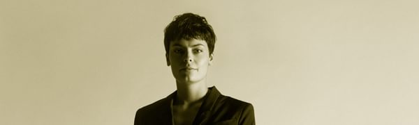 A women stands wearing a suit facing the camera