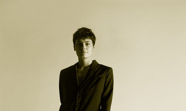 A women stands wearing a suit facing the camera