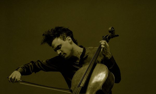 A man focused on playing a cello