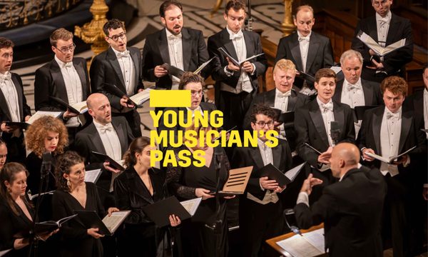 A yellow logo reading Young Musician's Pass overlays a choir dressed in formal wear sings in front of their conductor.