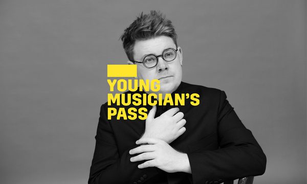 A yellow logo reading Young Musician's Pass overlays a man with round glasses with both hands held in front of his chest