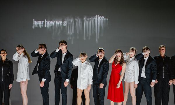 a row of people stand with there hands over their eyes