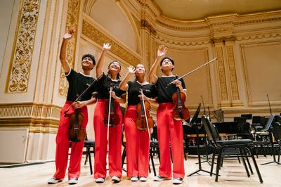 Four young musicians wave