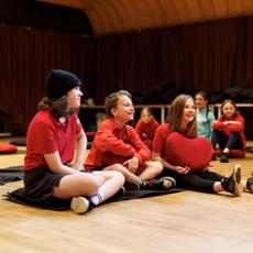 A small group of children sitting on the floor laughing