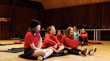 A small group of children sitting on the floor laughing
