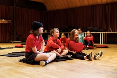A small group of children sitting on the floor laughing