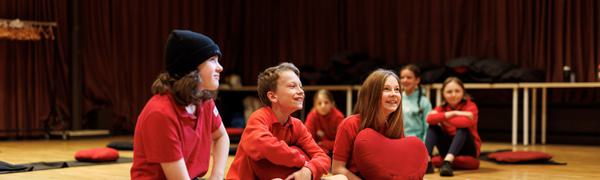 A small group of children sitting on the floor laughing
