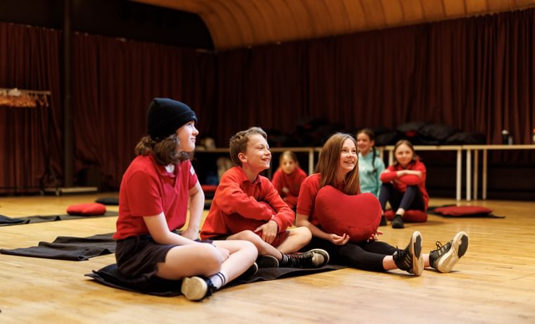 A small group of children sitting on the floor laughing