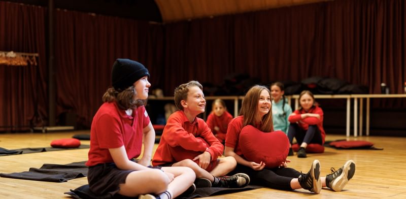 A small group of children sitting on the floor laughing