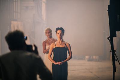 a young women faces the camera, an older women stands behind her