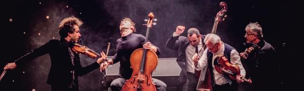 a group of five musicians have just finished playing and are posed dramatically