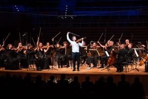 a group of string players flourish their bows in the air