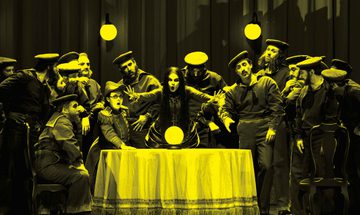 A black and yellow image of an opera singer singing while reaching over a table, surrounded by other performers