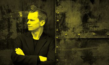 A black and yellow image of Steven Osborne leaning against a wall and looking away from the camera
