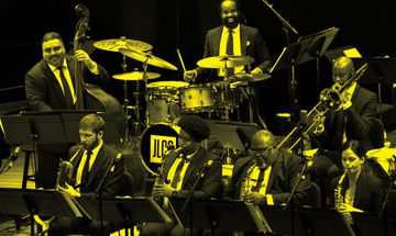 A black and yellow image of Jazz at Lincoln Center performing on stage
