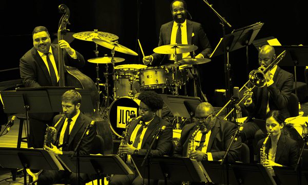 A black and yellow image of Jazz at Lincoln Center performing on stage