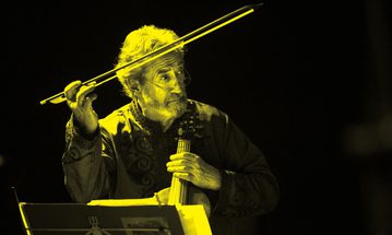 A black and yellow image of Jordi Savall holding a violin and pointing a bow in the air