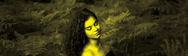 A black and yellow image of Julie Roset surrounded by leaves