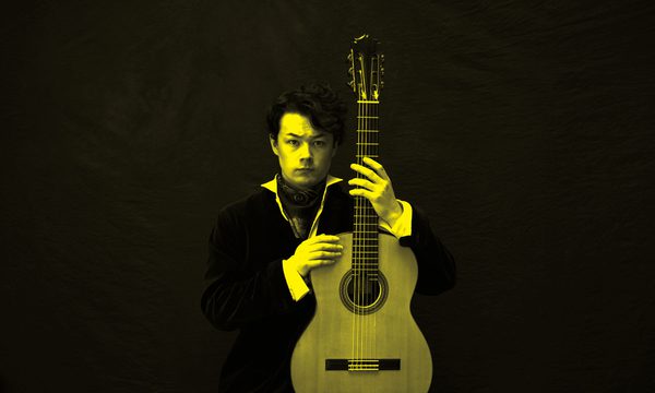 A black and yellow image of Sean Shibe holding a guitar and looking at the camera