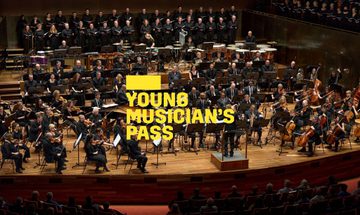 A yellow Young Musicians Pass logo in front of the Berlin Philharmoniker performing on stage