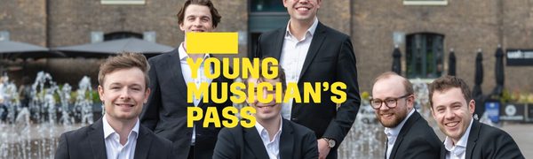 A yellow Young Musician's Pass logo in front of six men wearing suits sit and stand around a fountain