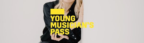 A yellow Young Musician's Pass logo in front of a woman dressed in black leans against a white wall while smiling into the distance