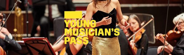 A yellow Young Musician's Pass logo in front of a woman singing on stage wearing a black top and a gold sparkly skirt while an orchestra plays behind her