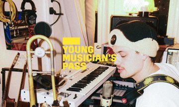 A yellow Young Musician's Pass logo in front of a person playing a guitar