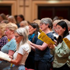 A group of people singing from books of sheet music