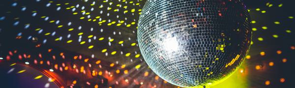 A disco ball fills a room with yellow and white light.