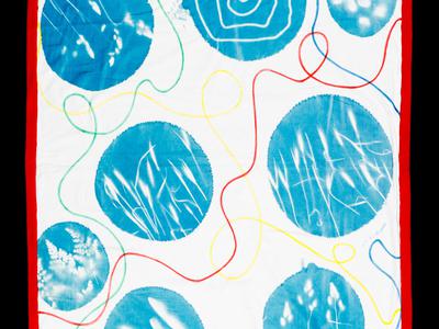A white blanket with blue circles across it with white drawings inside