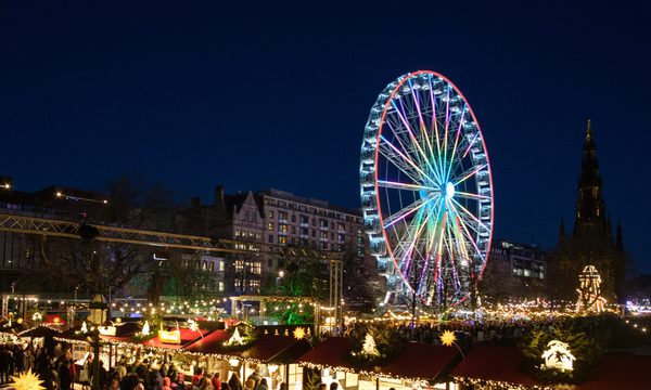 A ferris wheel is lit up against a dark night sky.