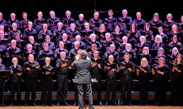 The Edinburgh Festival Chorus perform, standing five rows deep, with their conductor stood in front of them